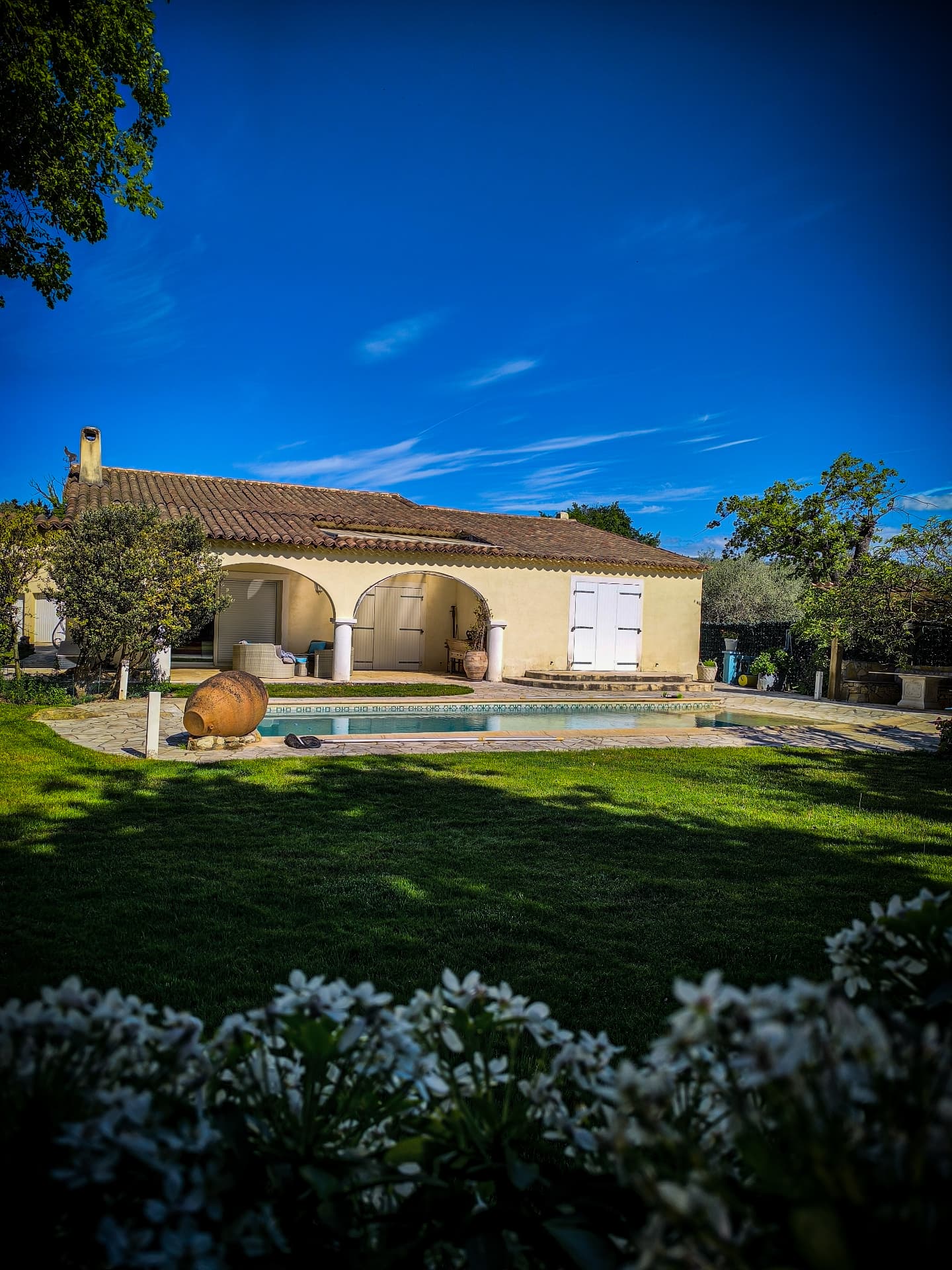 Jardin fleuri autour d’une maison et de sa piscine